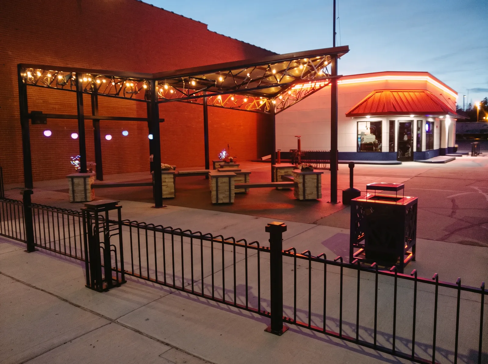 The courtyard at Pedalers Corner with picnic tables, string lights and a fire pit
